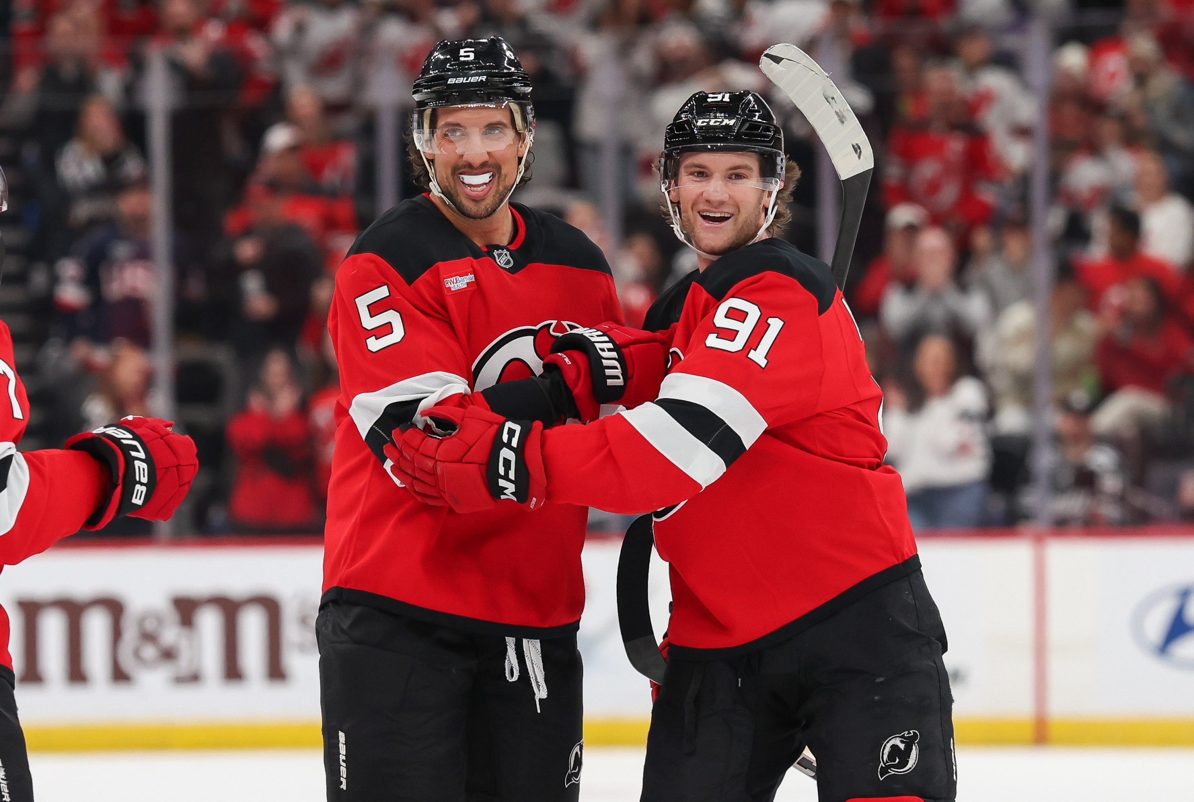 NEWARK, NEW JERSEY - OCTOBER 22: Brenden Dillon #5 of the New Jersey Devils celebrates with Dawson Mercer #91 of the New Jersey Devils after scoring a goal during the second period of a NHL game against the Minnesota Wild at Prudential Center on October 22, 2025 in Newark, New Jersey. (Photo by Andrew Mordzynski/Getty Images)