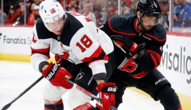 New Jersey Devils' Ondrej Palat (18) battles for the puck with Carolina Hurricanes' Shayne Gostisbehere (4) during the first period of an NHL hockey game in Raleigh, N.C., Thursday, Oct. 9, 2025. (AP Photo/Karl DeBlaker)
