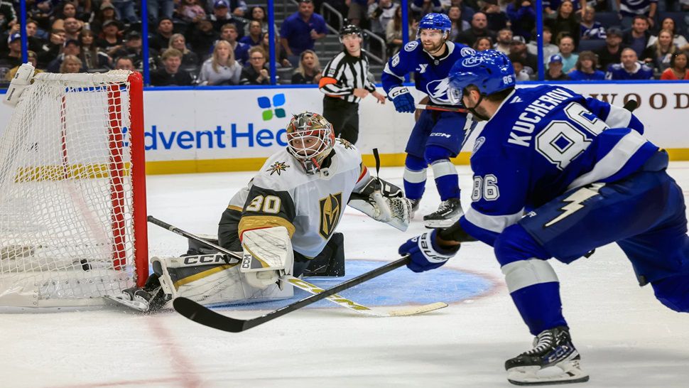 Tampa Bay Lightning's Nikita Kucherov, right, scores against Vegas Golden Knights goaltender Carl Lindbom, left, during the overtime period of an NHL hockey game Sunday, Oct. 26, 2025, in Tampa, Fla. (AP Photo/Mike Carlson)