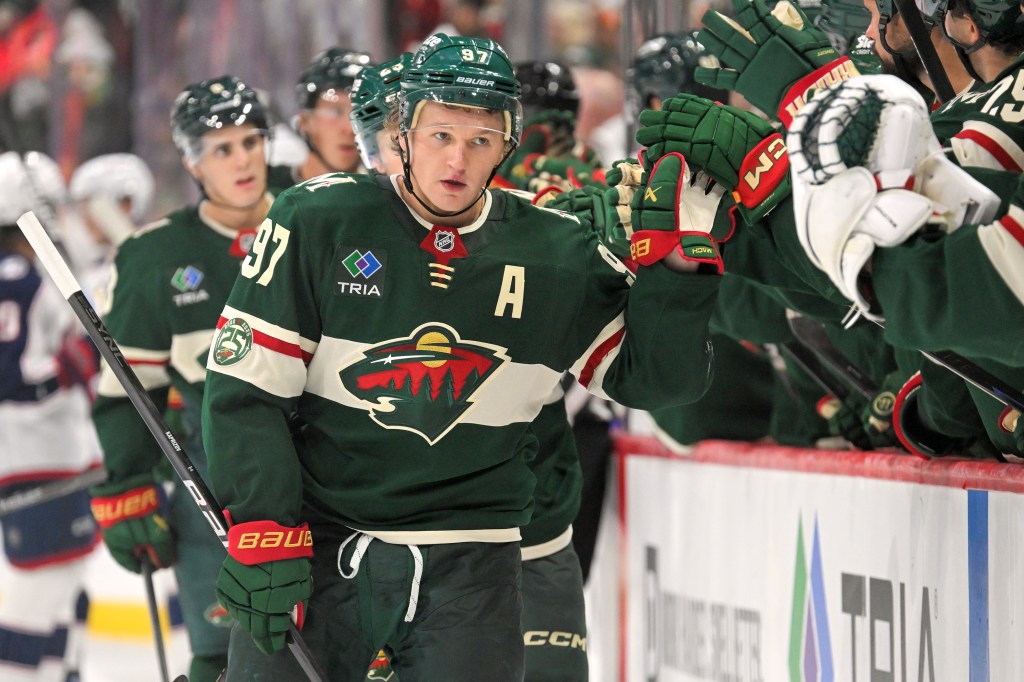 Kirill Kaprizov high-fives teammates after scoring a goal.