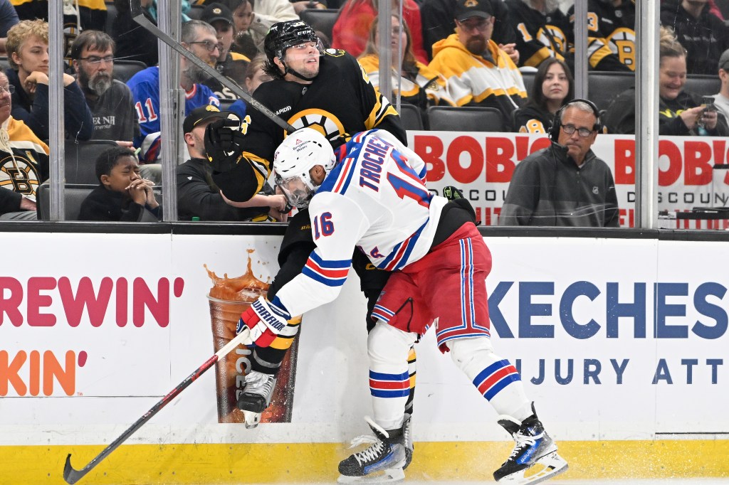 New York Rangers center Vincent Trocheck checks Boston Bruins defenseman Andrew Peeke into the boards.