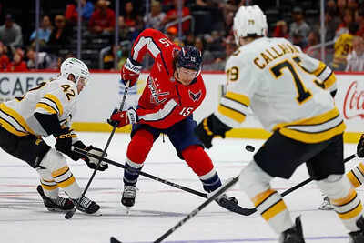 Sonny Milano of the Washington Capitals attempts an audacious net-front lacrosse goal against the Boston Bruins