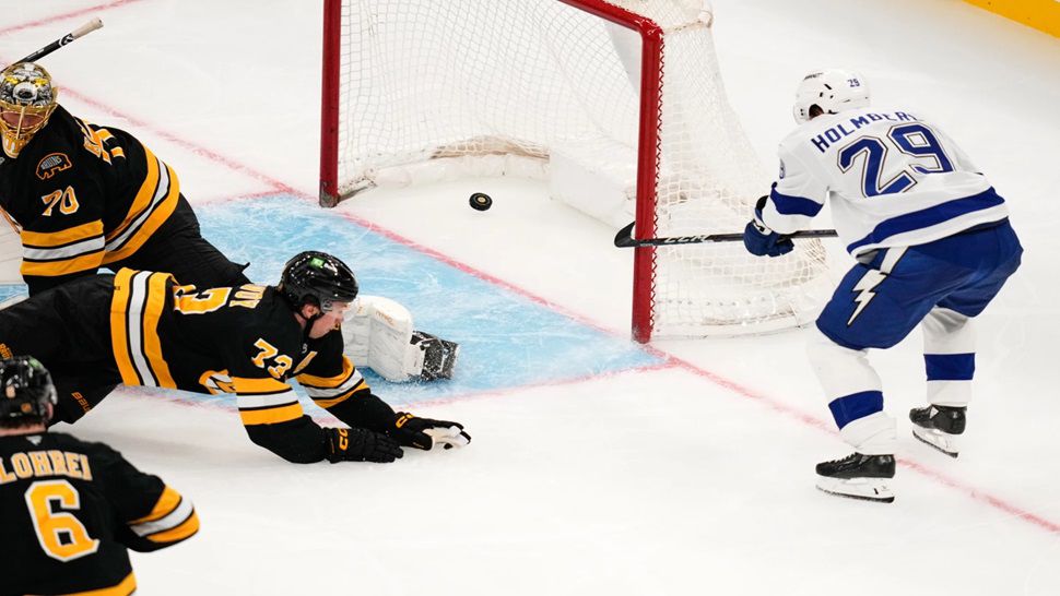 Tampa Bay Lightning right wing Pontus Holmberg (29) pokes the puck into the net, as Boston Bruins goaltender Joonas Korpisalo (70) looks back at the crease, during the second period of an NHL hockey game, Monday, Oct. 13, 2025, in Boston. (AP Photo/Charles Krupa)