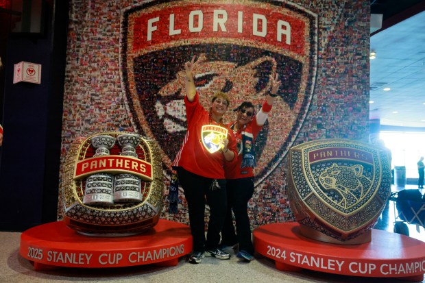 Kayla Almeida and her mom Rosanna Rebelled take photos with the replica championship rings before the start of the Florida Panthers home opener against the Chicago Blackhawks on Tuesday at Amerant Bank Arena in Sunrise. (Mike Stocker/South Florida Sun Sentinel)