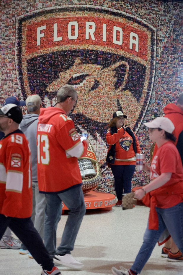 Kim Baston takes photos with the replica championship rings before...