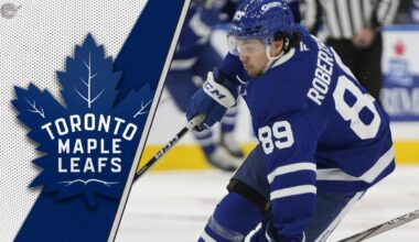 Toronto Maple Leafs forward Nick Robertson skates with the puck during an NHL game.