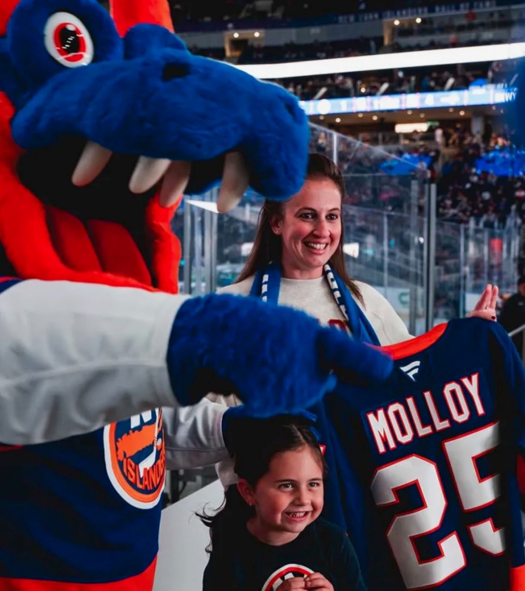 Janine Biscari, vice president of student affairs at Molloy University, with NY Islanders mascot Sparky, at UBS Arena before the New York Islanders' home opener.