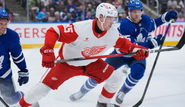 Elmer Soderblom (85) battles multiple members of the Toronto Maple Leafs for the puck.