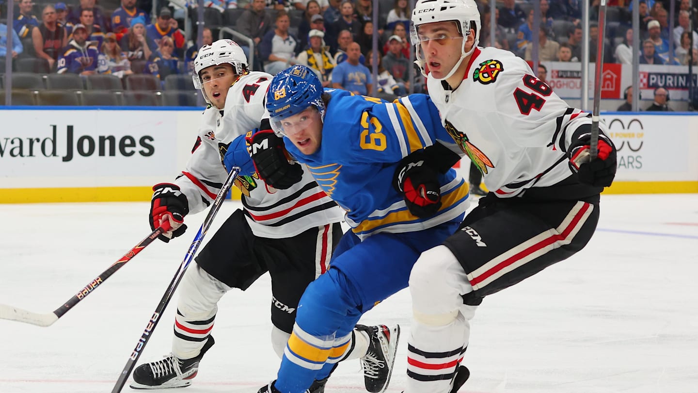 St. Louis Blues F Jake Neighbours engaged in a battle with two opposing skaters