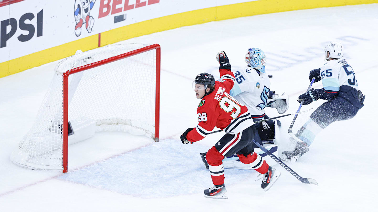 Nov 20, 2025; Chicago, Illinois, USA; Chicago Blackhawks center Connor Bedard (98) reacts to a lack of call against Seattle Kraken defenseman Ryan Lindgren (55) during the third period at United Center. Mandatory Credit: Kamil Krzaczynski-Imagn Images