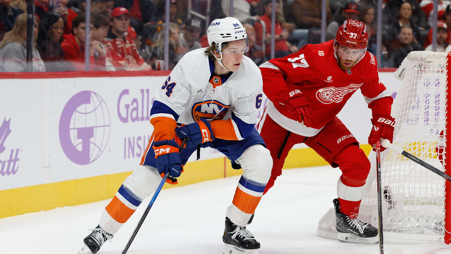 Nov 20, 2025; Detroit, Michigan, USA;  New York Islanders center Calum Ritchie (64) skates with the puck defended by Detroit Red Wings left wing J.T. Compher (37) in the first period at Little Caesars Arena. Mandatory Credit: Rick Osentoski-Imagn Images