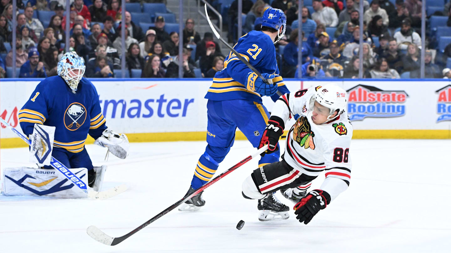 Nov 21, 2025; Buffalo, New York, USA; Chicago Blackhawks center Teuvo Teravainen (86) is knocked off his skates by Buffalo Sabres defenseman Conor Timmins (21) in front of goaltender Ukko-Pekka Luukkonen (1) in the third period at KeyBank Center. Mandatory Credit: Mark Konezny-Imagn Images