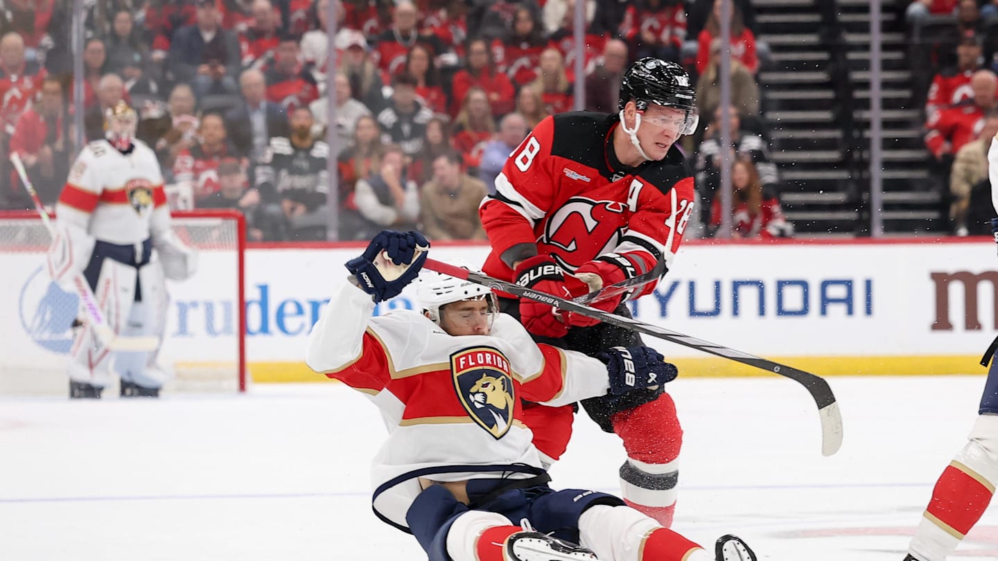 Oct 16, 2025; Newark, New Jersey, USA; New Jersey Devils left wing Ondrej Palat (18) hits Florida Panthers left wing A.J. Greer (10) during the first period at Prudential Center. Mandatory Credit: Ed Mulholland-Imagn Images