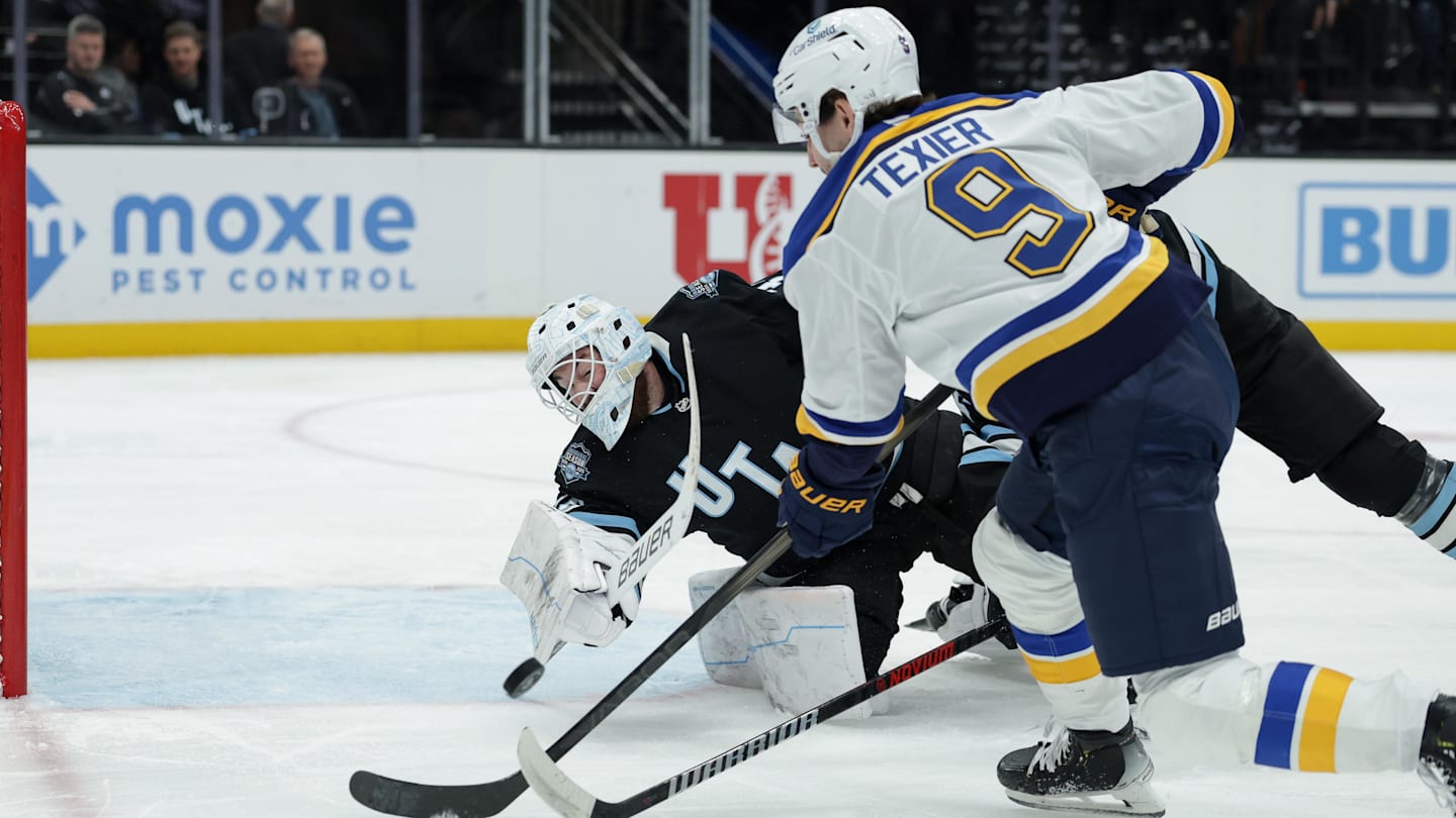 Feb 2, 2025; Salt Lake City, Utah, USA; Utah Hockey Club goaltender Connor Ingram (39) dives for the puck off of a St. Louis Blues center Alexandre Texier (9) shot during the first period at Delta Center. Mandatory Credit: Chris Nicoll-Imagn Images