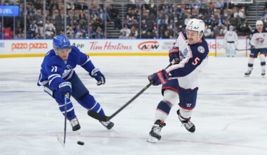 Blue Jackets defenseman Denton Mateychuk tries to fire a shot past Toronto forward Max Domi.