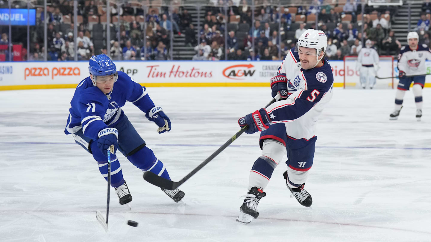 Blue Jackets defenseman Denton Mateychuk tries to fire a shot past Toronto forward Max Domi.