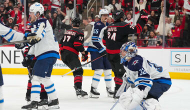 Nov 28, 2025; Raleigh, North Carolina, USA;  Carolina Hurricanes center Seth Jarvis (24) celebrates his goal past Winnipeg Jets goaltender Thomas Milic (32) and center Mark Scheifele (55) during the third period at Lenovo Center. Mandatory Credit: James Guillory-Imagn Images
