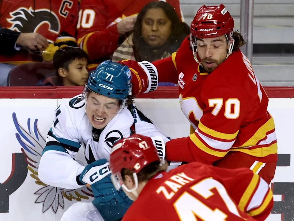  Flames forward Ryan Lomberg battles Sharks forward Macklin Celebrini on Thursday.