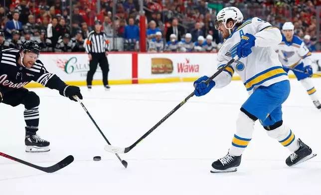 St. Louis Blues center Robert Thomas (18) scores a goal in front of New Jersey Devils left wing Ondrej Palat (18) during the first period of an NHL hockey game, Wednesday, Nov. 26, 2025, in Newark, N.J. (AP Photo/Noah K. Murray)