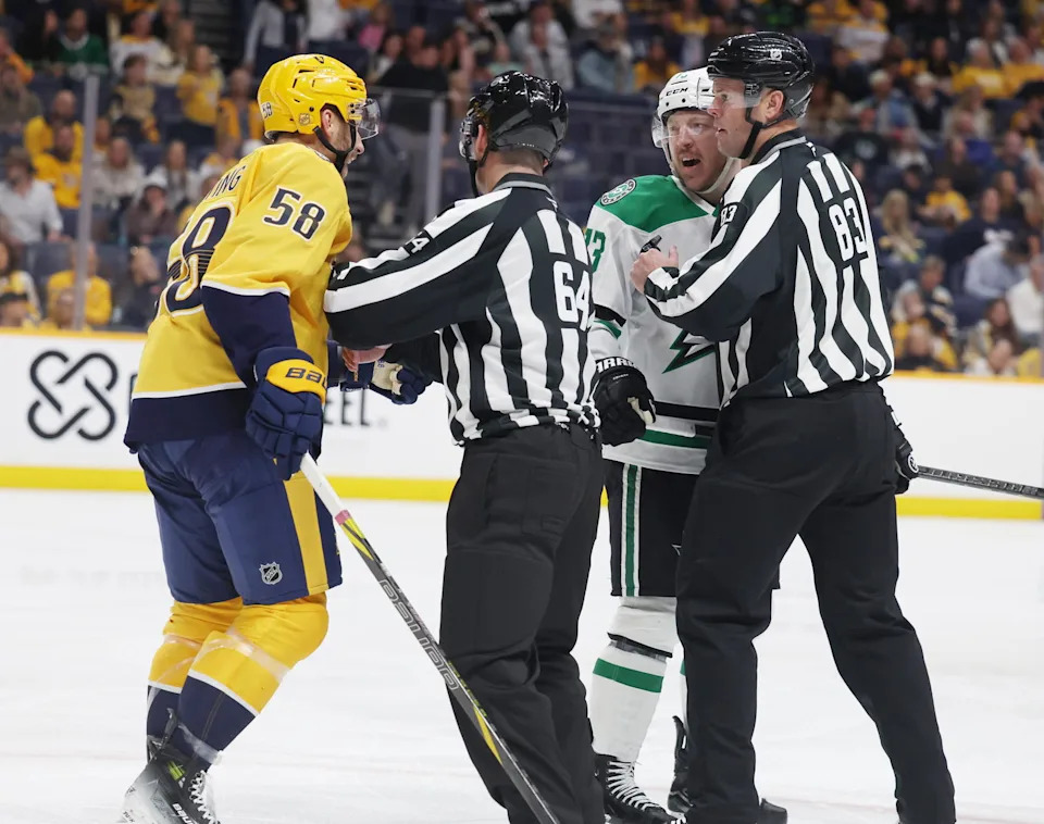 Nov 8, 2025; Nashville, Tennessee, USA; Nashville Predators left wing Michael Bunting (58) exchanges words with Dallas Stars left wing Adam Erne (73) as they are separated by refs during the third period at Bridgestone Arena. Mandatory Credit: Alan Poizner-Imagn Images