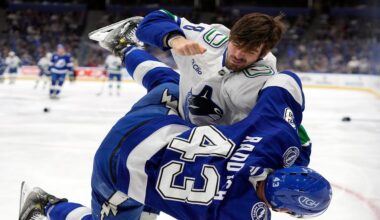 Vancouver Canucks right wing Conor Garland (8) knocks down Tampa Bay Lightning defenseman Darren Raddysh (43) as they fight during the first period of an NHL hockey game Sunday, Nov. 16, 2025, in Tampa, Fla. (AP Photo/Chris O'Meara)