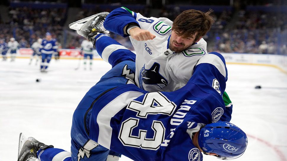 Vancouver Canucks right wing Conor Garland (8) knocks down Tampa Bay Lightning defenseman Darren Raddysh (43) as they fight during the first period of an NHL hockey game Sunday, Nov. 16, 2025, in Tampa, Fla. (AP Photo/Chris O'Meara)