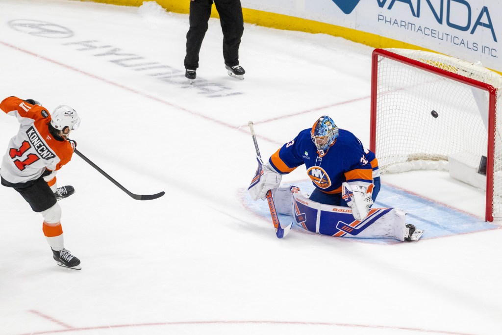 Travis Konecny of the Philadelphia Flyers scores a goal against New York Islanders goalie David Rittich.