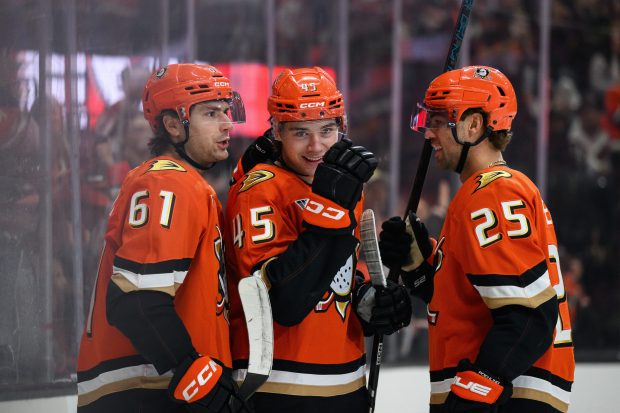 Ducks right wing Beckett Sennecke, center, reacts after scoring during...