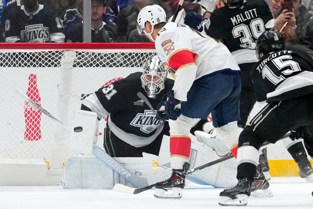 Florida Panthers center Sam Reinhart, middle, scores on Kings goaltender...