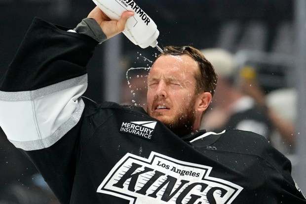 Kings goaltender Anton Forsberg sprays water on his face before...