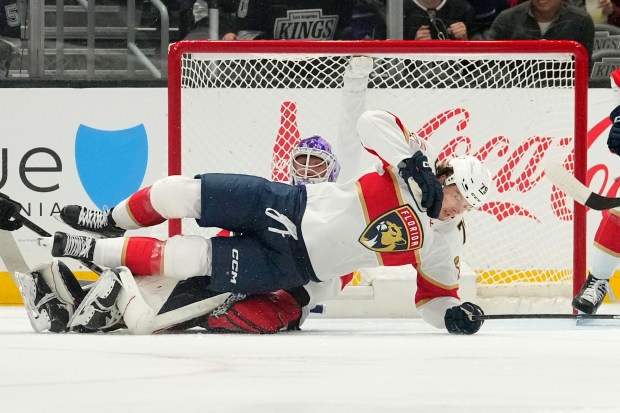Florida Panthers center Cole Schwindt right, trips over goaltender Sergei...