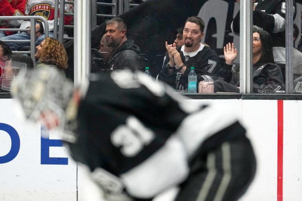 Dodgers pitcher Blake Snell, center back, claps as Kings goaltender...
