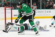 Dallas Stars center Tyler Seguin, top, prepares to score a goal on Seattle Kraken goaltender...