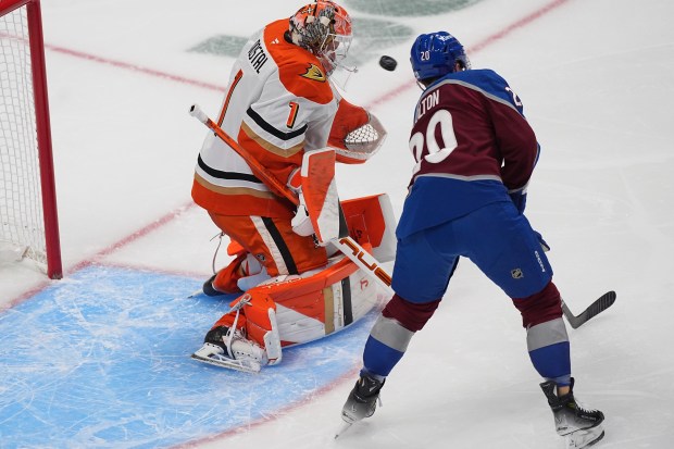 Ducks goaltender Lukas Dostal, left, stops a redirected shot off...