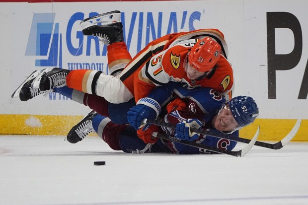 Ducks defenseman Olen Zellweger, top, lands on Colorado Avalanche left...