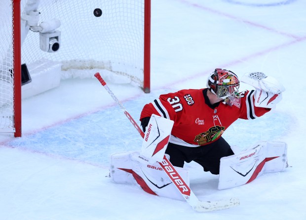 Blackhawks goaltender Spencer Knight is unable to stop the puck as Devils defenseman Simon Nemec scores the game-winning goal in overtime Wednesday, Nov. 12, 2025, at the United Center. (Chris Sweda/Chicago Tribune)