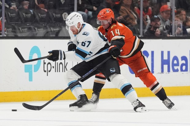 Ducks defenseman Drew Helleson, right, and Utah Mammoth left wing...
