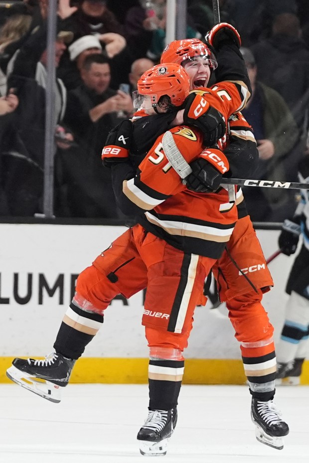 Ducks defenseman Olen Zellweger, front, celebrates his game-winning overtime goal...