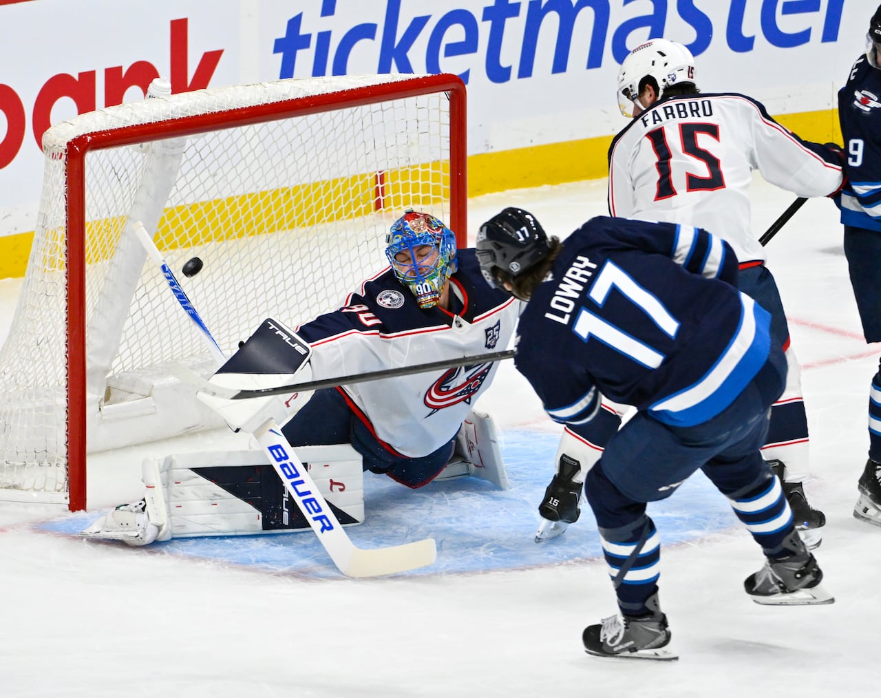 A Jets player shoots the puck into the net on his forehand beyond the reach of the goaltender's blocker.