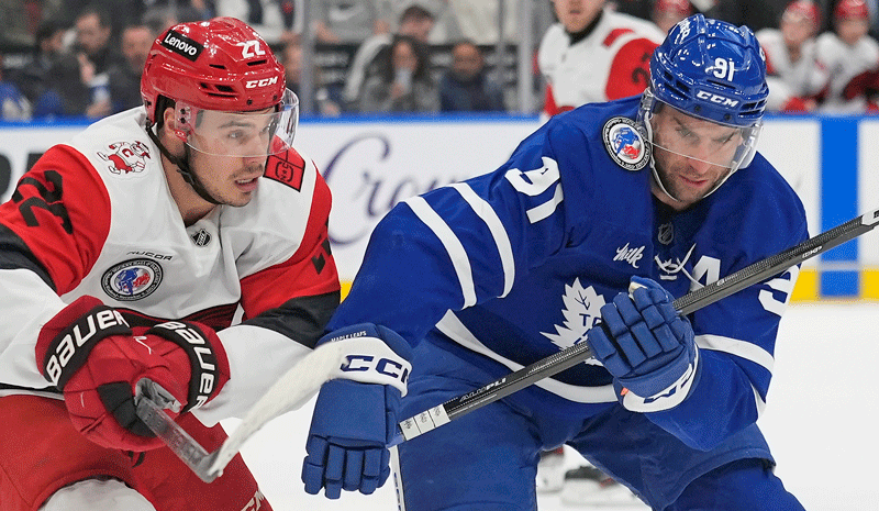 Toronto Maple Leafs forward John Tavares (91) and Carolina Hurricanes forward Logan Stankoven (22) chase after a loose puck during the first period at Scotiabank Arena.