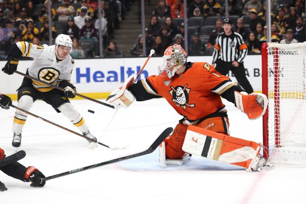 Ducks goaltender Lukas Dostal, right, blocks a shot on goal...