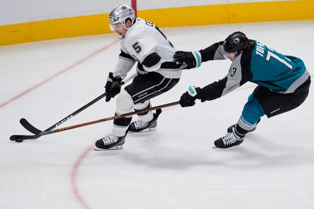 Kings defenseman Cody Ceci, left, and San Jose Sharks center...