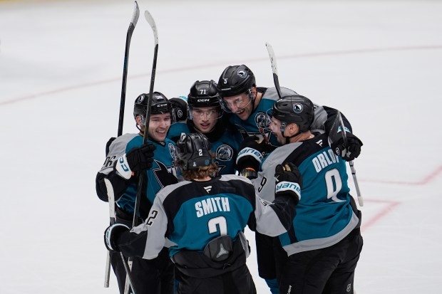 San Jose Sharks center Philipp Kurashev, left, celebrates with teammates...