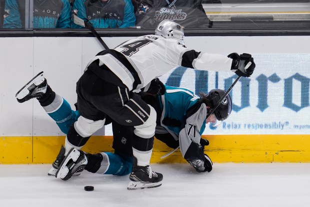 Kings defenseman Mikey Anderson, left, collides with San Jose Sharks...