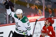 Dallas Stars forward Jason Robertson, left, celebrates his goal as Calgary Flames defenseman...