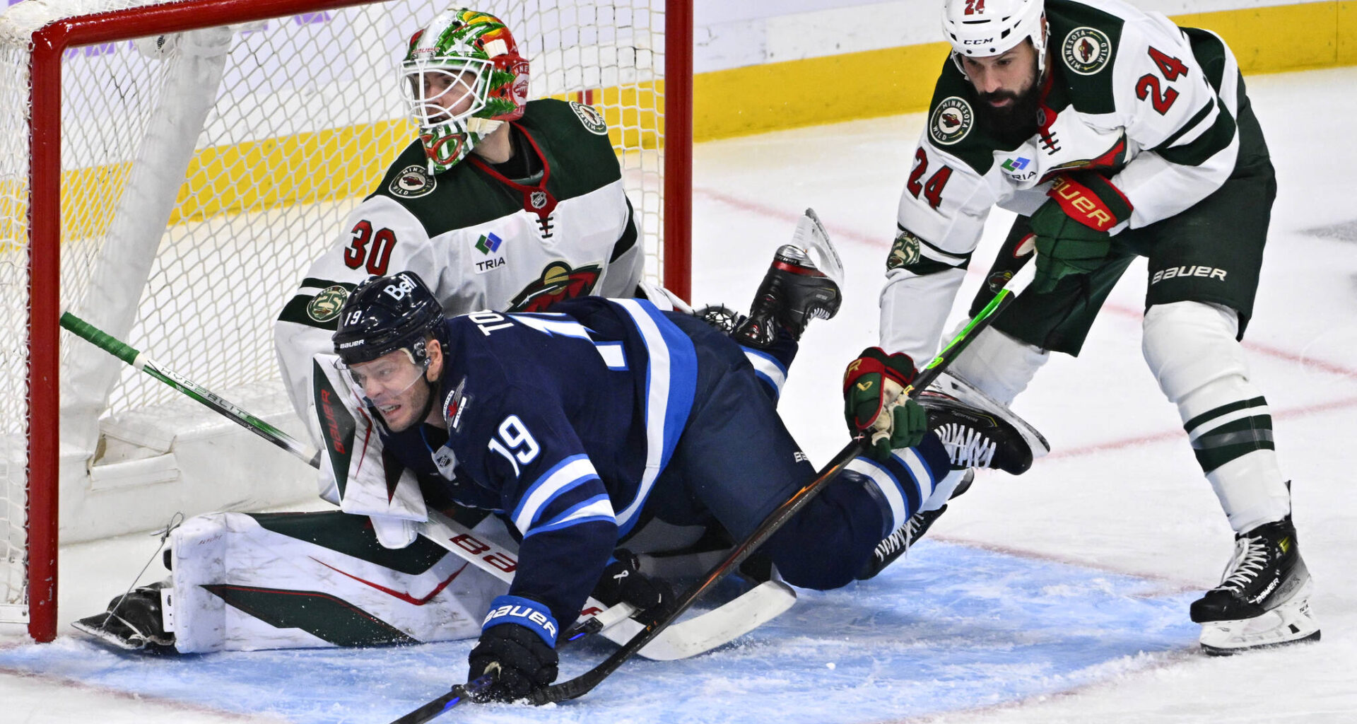Minnesota Wild Zach Bogosian (24) dumps Winnipeg Jets&rsquo; Jonathan Toews (19) in front of his goaltender Jesper Wallstedt (30) during first period of Sunday&rsquo;s game. (Fred Greenslade / The Canadian Press)