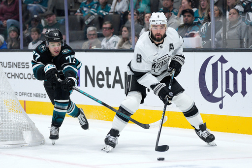 Los Angeles Kings defenseman Drew Doughty (8) looks to pass the puck against San Jose Sharks center Michael Misa (77) during the first period of an NHL hockey game in San Jose, Calif., Tuesday, Oct. 28, 2025. (AP Photo/Tony Avelar)