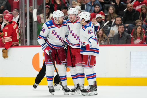 New York Rangers left wing Alexis Lafreni&egrave;re, center, celebrates his goal with defenseman Vladislav Gavrikov, left, and left wing Conor Sheary during the third period of an NHL hockey game against the Detroit Red Wings Friday, Nov. 7, 2025, in Detroit. (AP Photo/Ryan Sun)