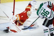 Dallas Stars' Mikko Rantanen, right, has his shot stopped by Calgary Flames goalie Devin...