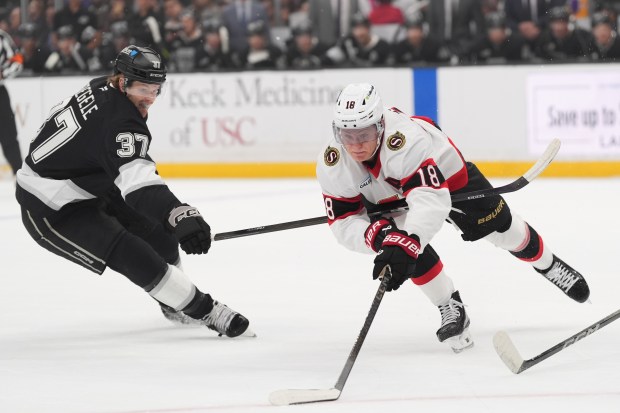 Ottawa Senators center Tim Stützle, right, moves the puck as...